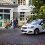 Une patiente en fauteuil roulant accompagnée de deux personnes du service de taxi médical (VSL) s'appretent à rentrer à la Clinique Médicale Brugnon Agache.