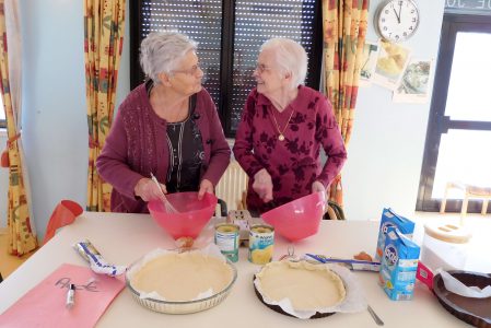 Deux dames se regardant et préparant une tarte